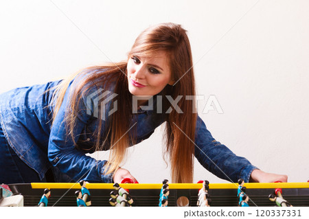 woman playing table football game woman playing table football game 120337331