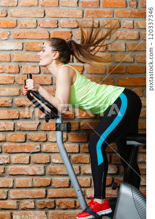 Active woman using exercise bike at the gym. Active woman using exercise bike at the gym. 120337346