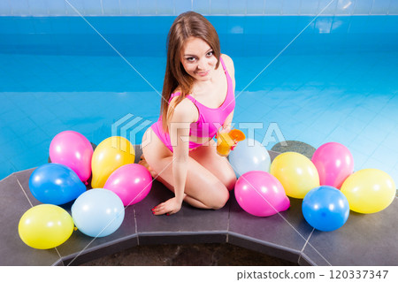 Girl relaxing at swimming pool with drink Girl relaxing at swimming pool with drink 120337347