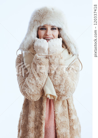 happy stylish woman warming hands with breath on white happy stylish woman warming hands with breath on white 120337418