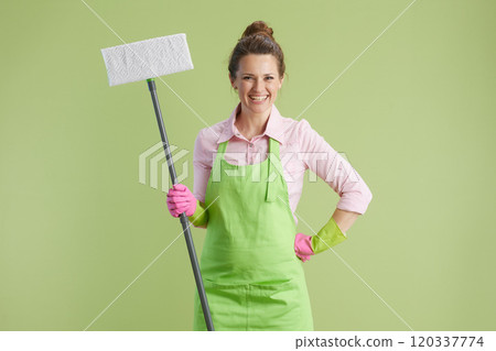 happy woman in green apron and rubber gloves isolated on green happy woman in green apron and rubber gloves isolated on green 120337774