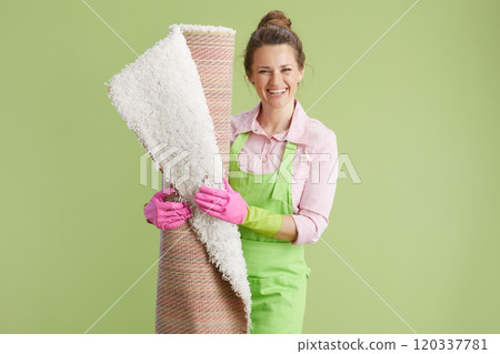 smiling modern female with white carpet isolated on green smiling modern female with white carpet isolated on green 120337781