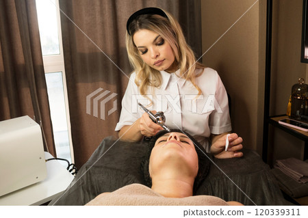 Aesthetician performing jet peeling facial on client Aesthetician performing jet peeling facial on client 120339311