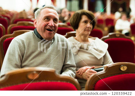 Mature man and woman in theater watching a performance 120339422