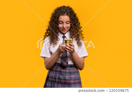 Girl using smartphone, focused expression, school attire. Girl using smartphone, focused expression, school attire. 120339675