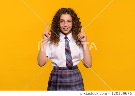 Girl wearing glasses pointing upwards with both hands Girl wearing glasses pointing upwards with both hands 120339676