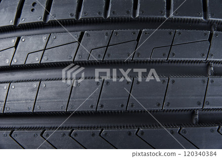 Detailed close up of tread pattern on new summer car tire Detailed close up of tread pattern on new summer car tire 120340384