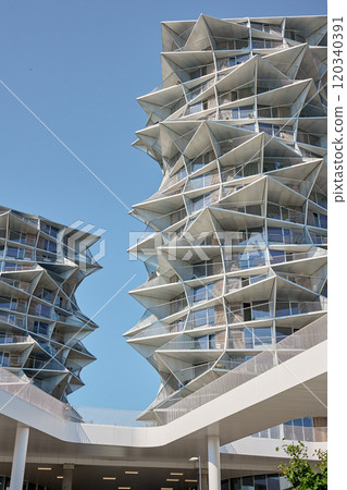 Low angle view of modern apartment buildings with geometric design against clear blue sky. Contemporary architectural design 120340391