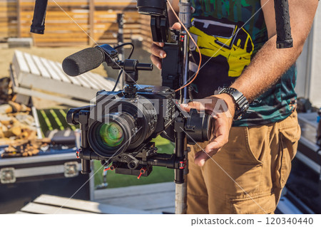 Steadicam operator prepare camera and 3-axis stabilizer-gimbal for a commercial shoot Steadicam operator prepare camera and 3-axis stabilizer-gimbal for a commercial shoot 120340440