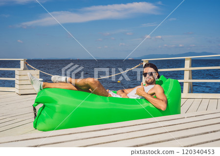 Young man enjoying leisure, lying on the air sofa Lamzac, near the sea Young man enjoying leisure, lying on the air sofa Lamzac, near the sea 120340453