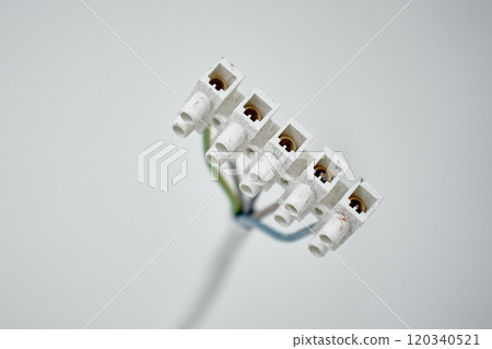 Close-up of electrical wires extending from white wall. Electrical work during apartment renovation. Electricity cable in new apartment 120340521