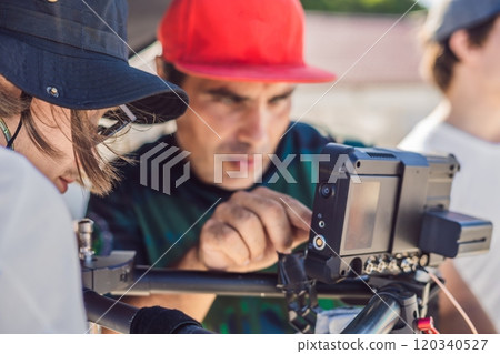 Steadicam operator and his assistant prepare camera and 3-axis stabilizer-gimbal for a commercial shoot 120340527