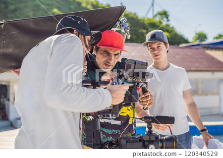 Steadicam operator and his assistant prepare camera and 3-axis stabilizer-gimbal for a commercial shoot 120340529