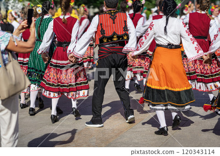 Traditional folk dancers in colorful costumes performing a lively dance during cultural festival 120343114