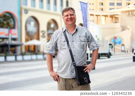 Adult blond man in short sleeve shirt on the street of a big city 120343230