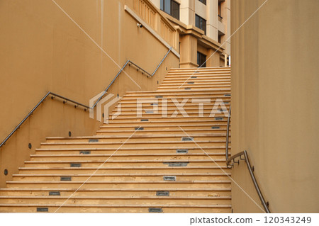 A narrow staircase between walls and tall buildings in an eastern city 120343249