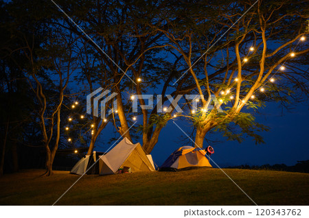camping tent on grass courtyard and warm night light under dark blue sky. Family vacation picnic on holiday relax. camping tent on grass courtyard and warm night light under dark blue sky. Family vacation picnic on holiday relax. 120343762