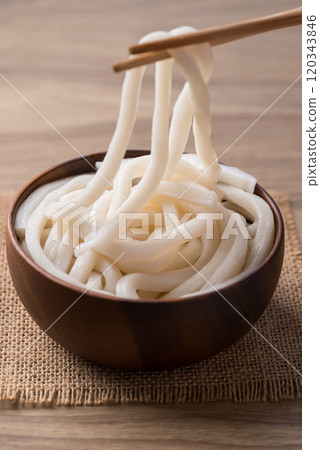 Udon noodles in wooden bowl with chopsticks, Thick noodles in Japanese cuisine Udon noodles in wooden bowl with chopsticks, Thick noodles in Japanese cuisine 120343846
