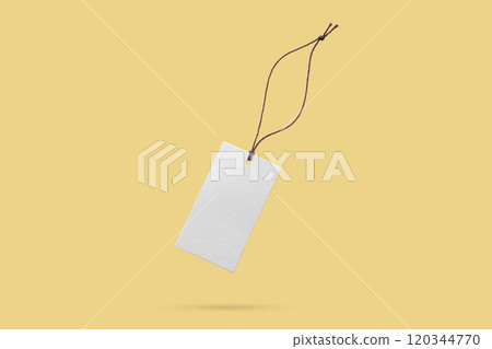 Blank price tag tied with string float on yellow background Blank price tag tied with string float on yellow background 120344770