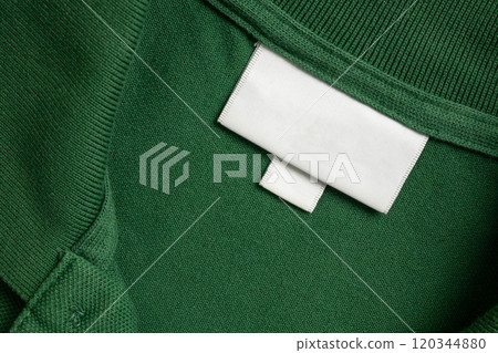 Blank white laundry care clothes label on green shirt fabric texture background Blank white laundry care clothes label on green shirt fabric texture background 120344880