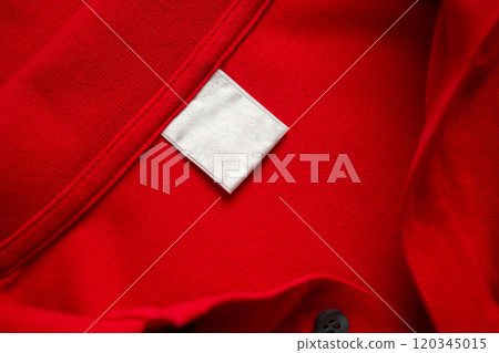 Blank white laundry care clothes label on red shirt fabric texture background 120345015