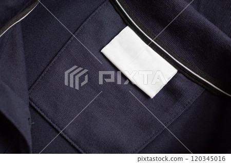Blank white laundry care clothes label on black shirt fabric texture background 120345016