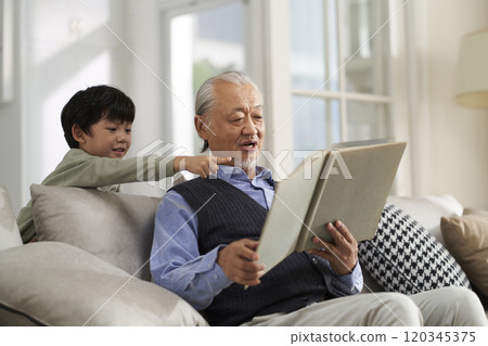 elderly asian grandfather having a good time with grandson at home elderly asian grandfather having a good time with grandson at home 120345375