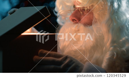 Santa Claus peeks inside the gift package 120345529