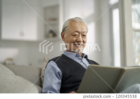 asian old man reading book at home 120345538