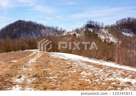 season change in carpathian mountains. cold environment concept. sunny day in spring. leafless forest and snow on the hill. beautiful scenery season change in carpathian mountains. cold environment concept. sunny day in spring. leafless forest and snow on the hill. beautiful scenery 120345851