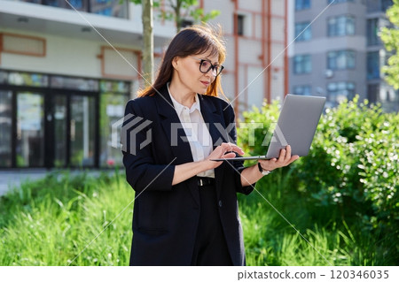 Portrait confident business successful mature woman, outdoors, urban background Portrait confident business successful mature woman, outdoors, urban background 120346035