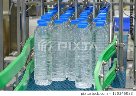 The group of filled drinking water bottles on the conveyor belt. The group of filled drinking water bottles on the conveyor belt. 120346088