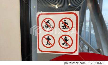 Sign on glass with symbols prohibiting use of personal transport for safety reason Sign on glass with symbols prohibiting use of personal transport for safety reason 120346636