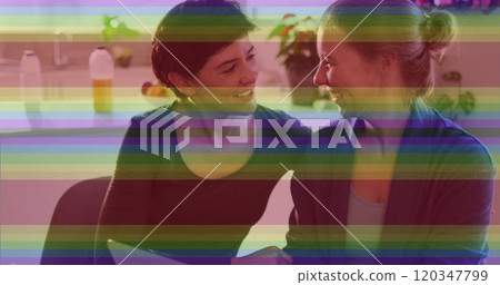 Image of pride rainbow stripes over happy caucasian lesbian couple using laptop at home Image of pride rainbow stripes over happy caucasian lesbian couple using laptop at home 120347799