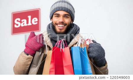 Winter shopping: smiling male model with gloves and colorful bags near sale sign 120349003