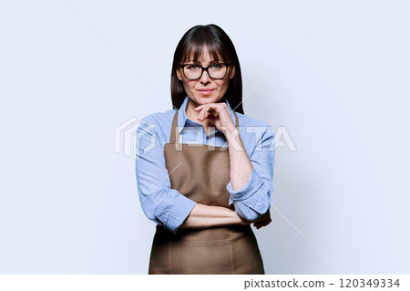 Portrait of middle aged woman in apron on white studio background 120349334