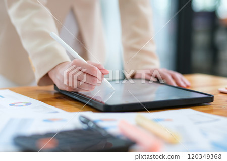 Close-up of hand signing electronic documents on a tablet with a digital pen for online workflows 120349368