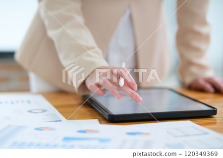 Close-up of hand signing electronic documents on a tablet with a digital pen for online workflows 120349369