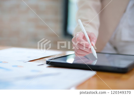 Close-up of hand signing electronic documents on a tablet with a digital pen for online workflows 120349370