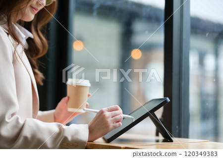 Close-up of a businesswoman using a tablet and stylus for work Close-up of a businesswoman using a tablet and stylus for work 120349383