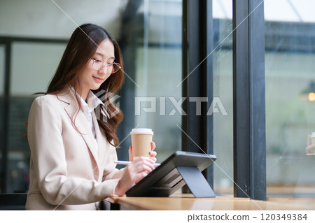 Professional businesswoman using a tablet and digital pen for analysis, design, and planning. Professional businesswoman using a tablet and digital pen for analysis, design, and planning. 120349384