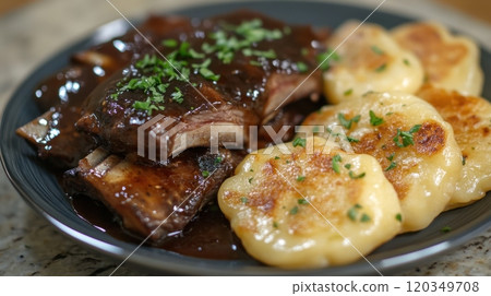 Savory bbq ribs with herb garnish and golden potatoes on a rustic plate 120349708