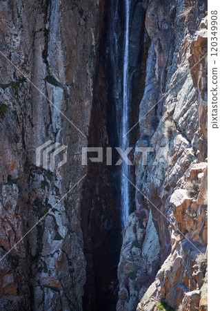 Stream between steep cliffs. Small waterfall in rock 120349908