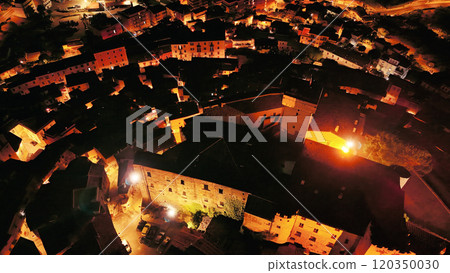 Aerial view of small town illuminating the night with warm lights Aerial view of small town illuminating the night with warm lights 120350030