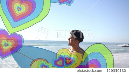Image of colourful hearts over african american man holding surfboard and walking on beach 120350180