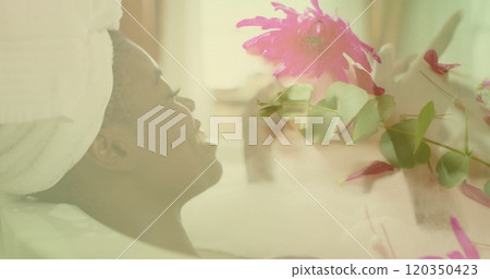 Image of pink flowers over happy african american woman relaxing in bathtub Image of pink flowers over happy african american woman relaxing in bathtub 120350423