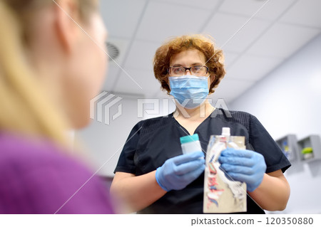 A nurse in the laboratory offers the patient a medical balloon for blowing to perform a test for Helicobacter A nurse in the laboratory offers the patient a medical balloon for blowing to perform a test for Helicobacter 120350880