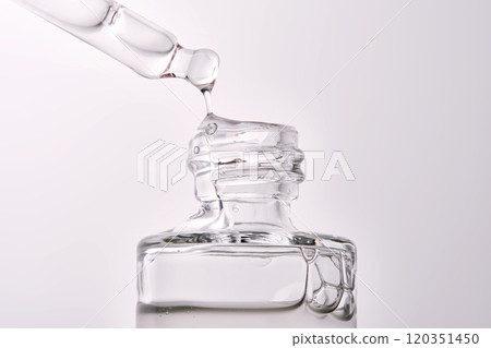Close-up of a cosmetic bottle with a pipette showing the texture of the serum. 120351450