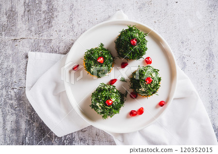 Close up of tuna, egg and dill salad shaped like Christmas trees on crackers on a plate top view 120352015