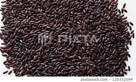 Close up of black rice grains scattered on white background, top view. Wild rice texture. Suitable for food and nutrition related content. Ideal for use in culinary and health-related designs 120352094